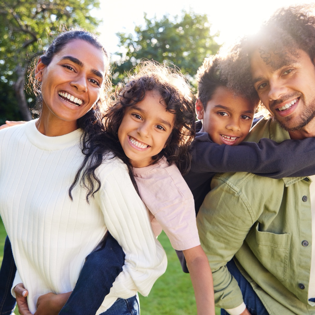 A family smiling together in a sunny garden