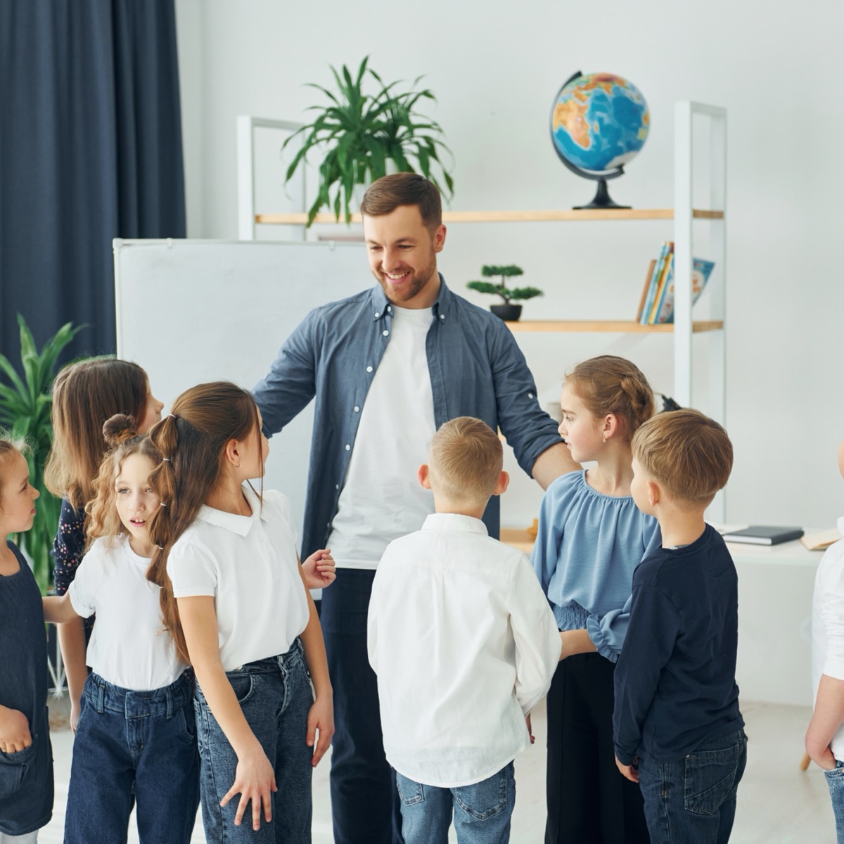 A provider working with a group of children in a bright classroom
